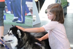 Girl pets Husky dog