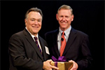 Two men exchange an award