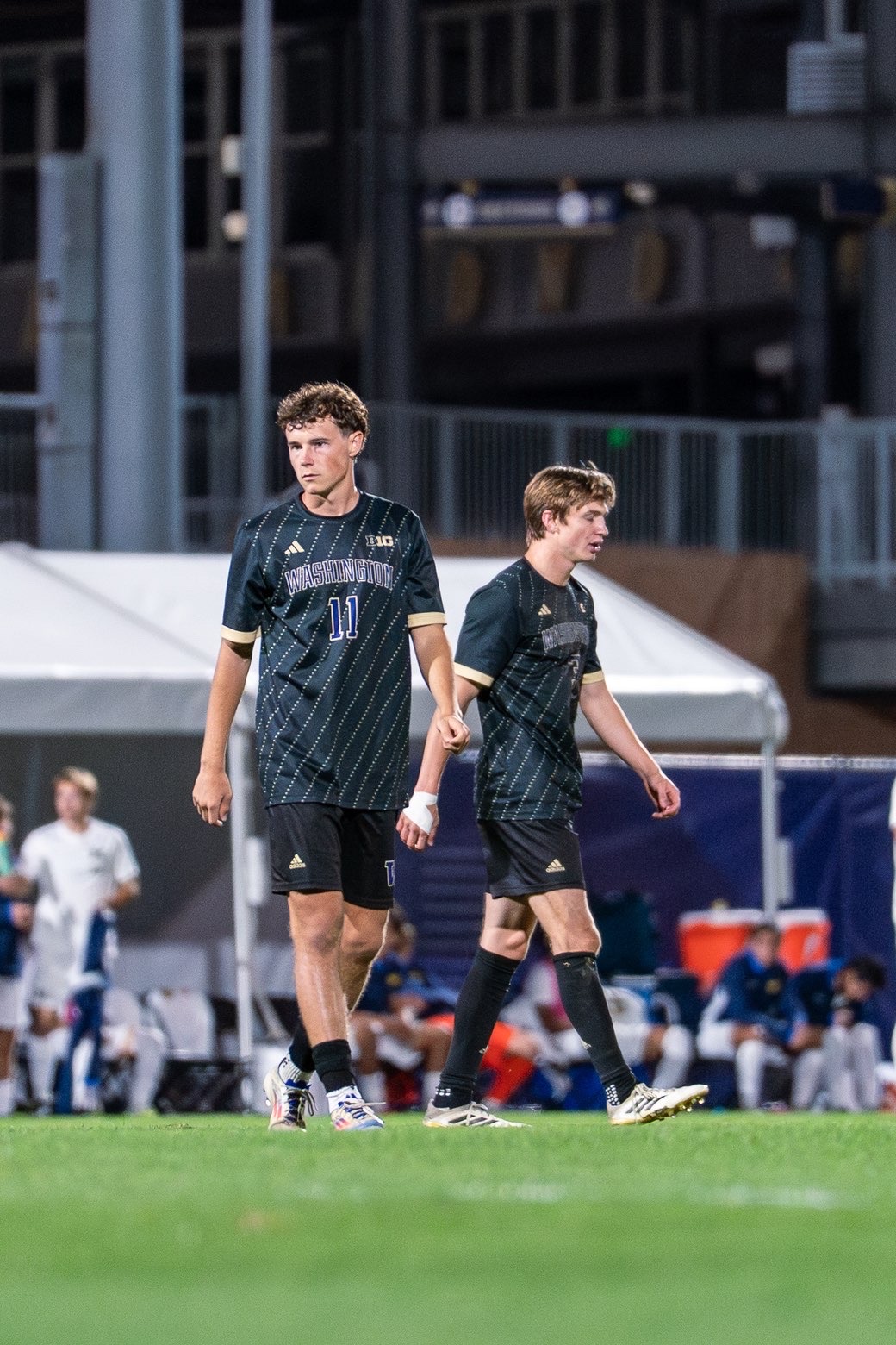 Nick O'Brien (left) walking across the soccer field during a game.