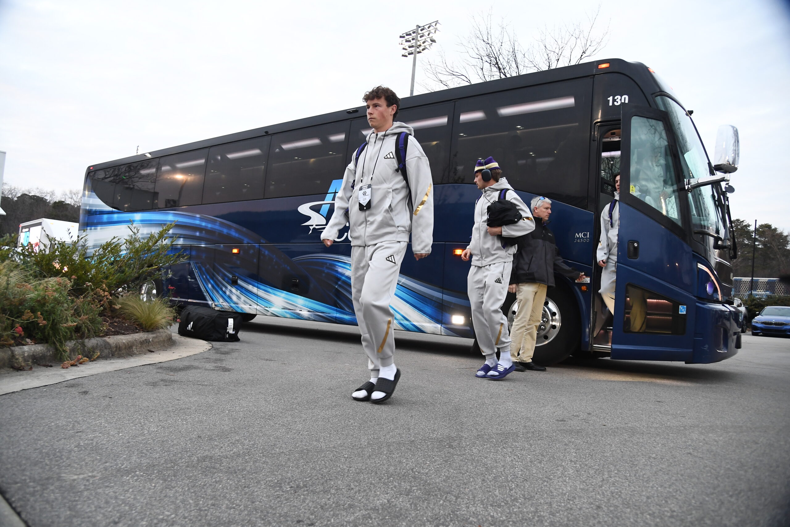 Nick O'Brien (center) walking off the soccer team's bus as they arrive at a game.