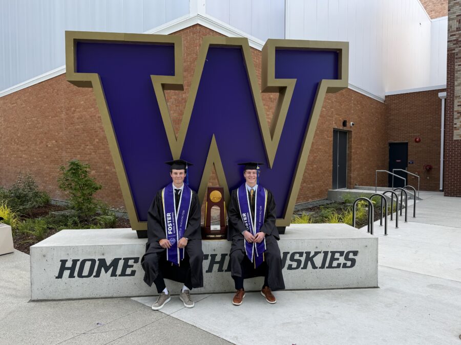 Nick O'Brien (left) and his teammate, Joe Dale (right), posing in front of the block W sign at their graduation.