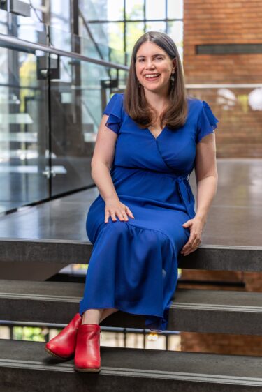 Alicia DeSantola sits outside a classroom in the PACCAR Building at the University of Washington Foster School of Business. Her research examines entrepreneurship, innovation, and the cultivated meat industry.